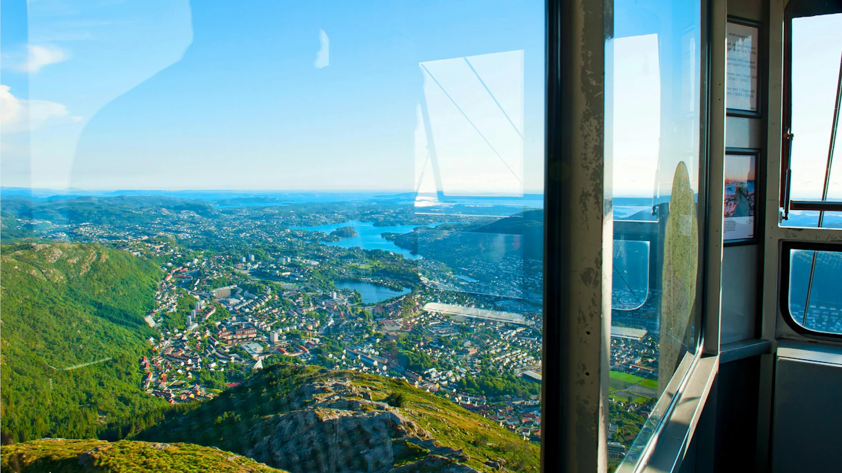 View from Ulriken Cable Car overlooking Bergen, Norway with mountains and cityscape.