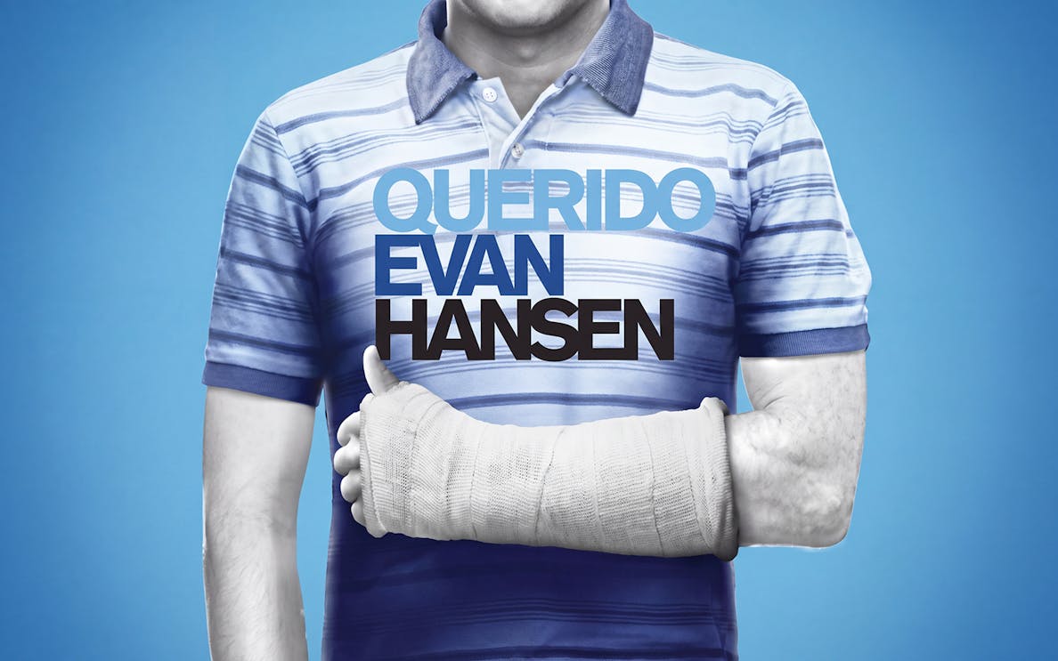 Man in striped shirt with arm cast, text "Querido Evan Hansen" on chest.