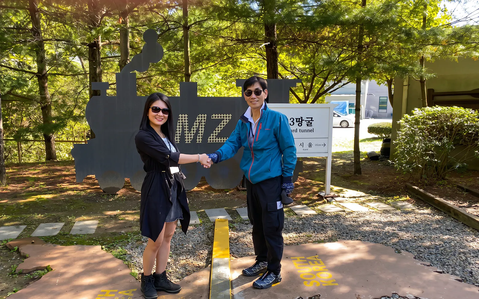 Visitors shaking hands at DMZ Third Tunnel entrance, South Korea.