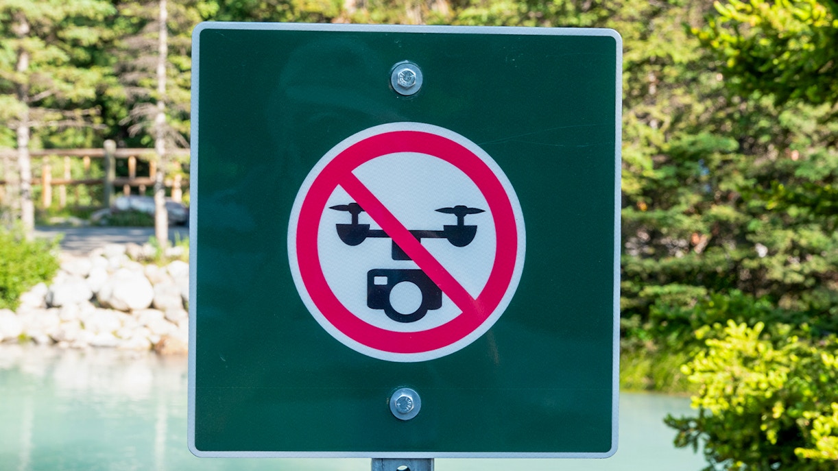 No drone sign in a natural park setting.