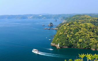 Tour boat navigating around Kinomatsushima's lush green islands and coastal waters.
