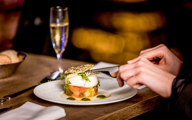 Person dining on gourmet dish during Seine River cruise in Paris.