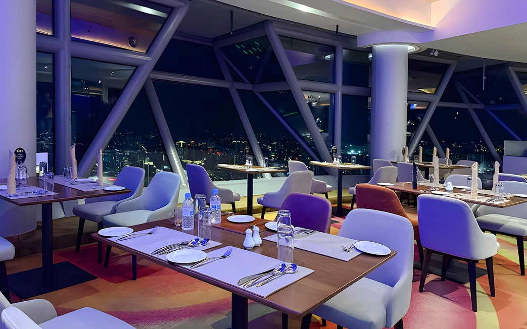 Dining area with city view at Orbit Revolving Restaurant, KL Tower, Kuala Lumpur.