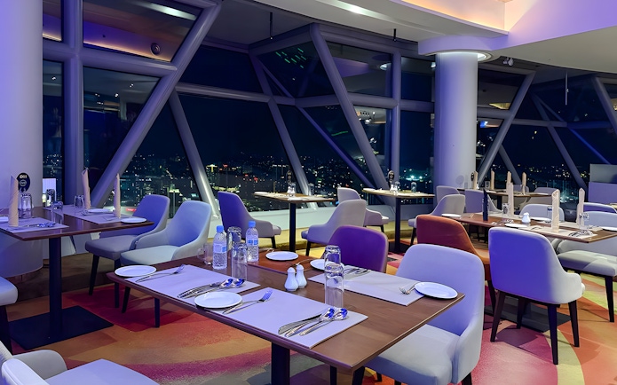 Dining area with city view at Orbit Revolving Restaurant, KL Tower, Kuala Lumpur.