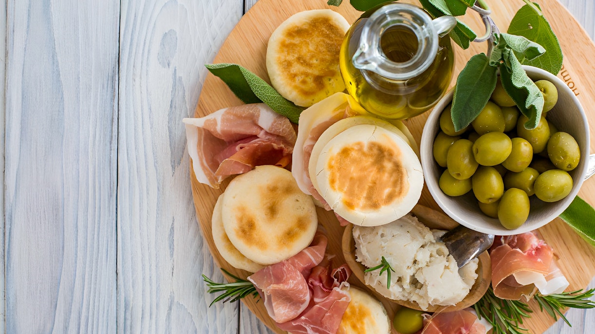 Aperitif platter with olives, prosciutto, and tigelle at Acetaia La Vedetta, Modena.
