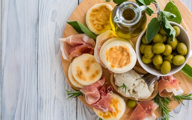 Aperitif platter with olives, prosciutto, and tigelle at Acetaia La Vedetta, Modena.