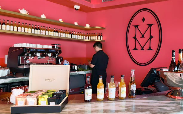 Barista preparing drinks at The View at The Palm, Dubai, with colorful beverage display.