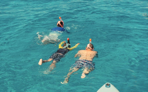 Snorkelers exploring clear waters at Cala Bassa Beach, Ibiza, Spain.