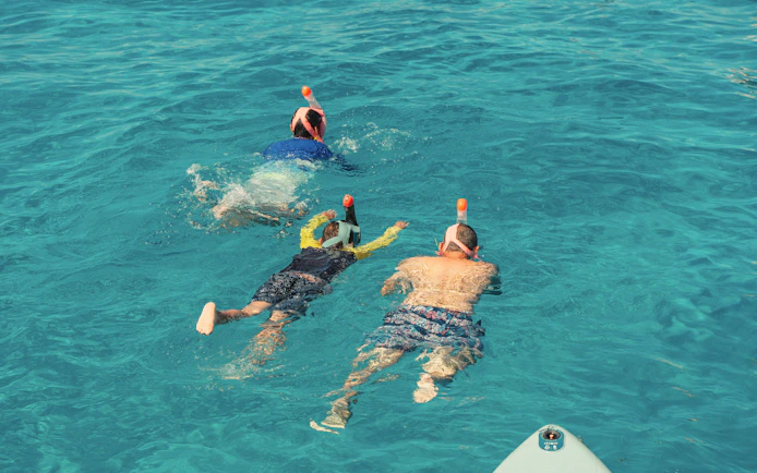 Snorkelers exploring clear waters at Cala Bassa Beach, Ibiza, Spain.
