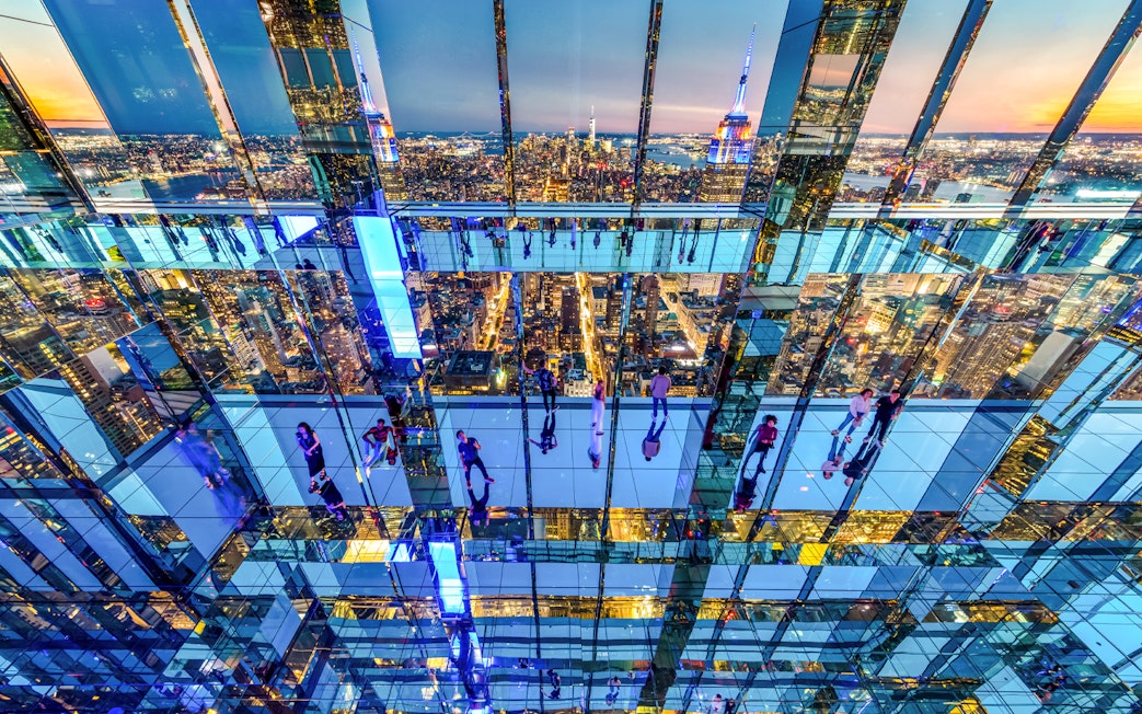 Interior view of SUMMIT One Vanderbilt with mirrored reflections and New York City skyline.