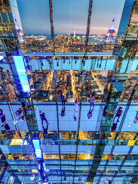 Interior view of SUMMIT One Vanderbilt with mirrored reflections and New York City skyline.