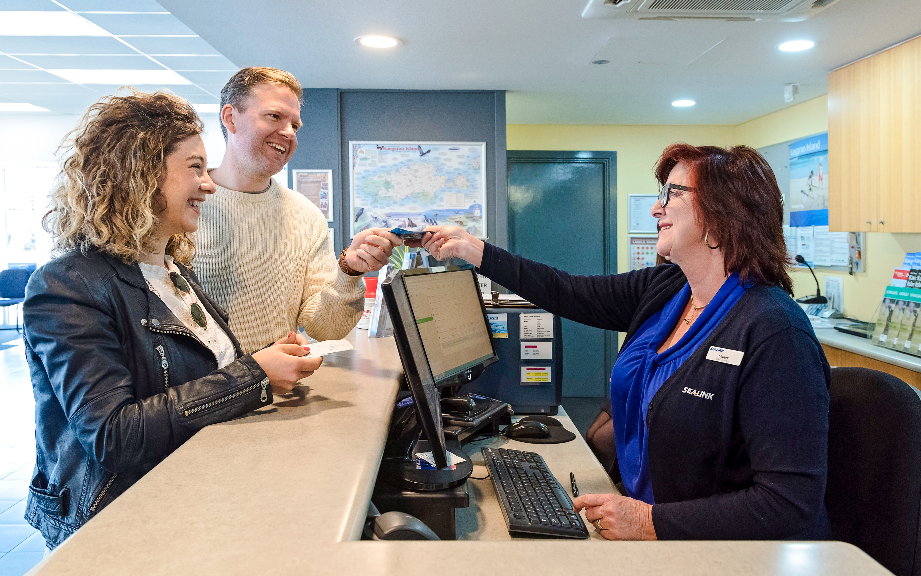 Couple receiving ferry tickets at Kangaroo Island ticket counter.