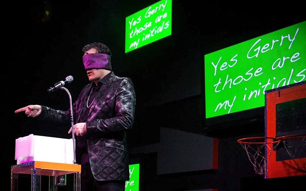 Performer blindfolded on stage during The Mentalist show, pointing at audience.