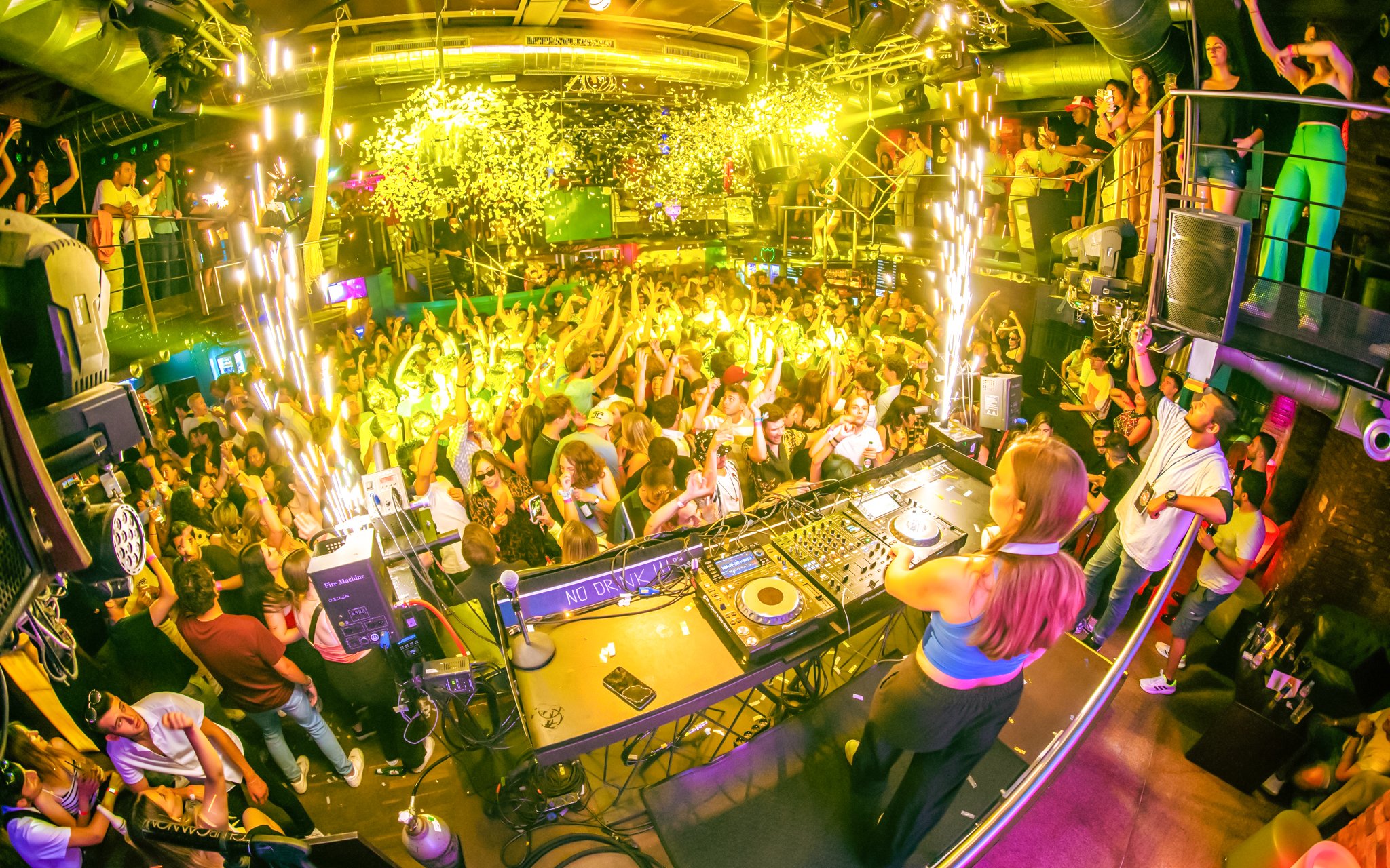 DJ playing at a lively sunset boat party in Prague with a crowd dancing.