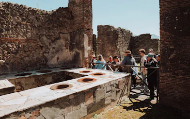 Tour group exploring ancient ruins in Pompeii, Italy.