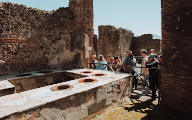 Tour group exploring ancient ruins in Pompeii, Italy.