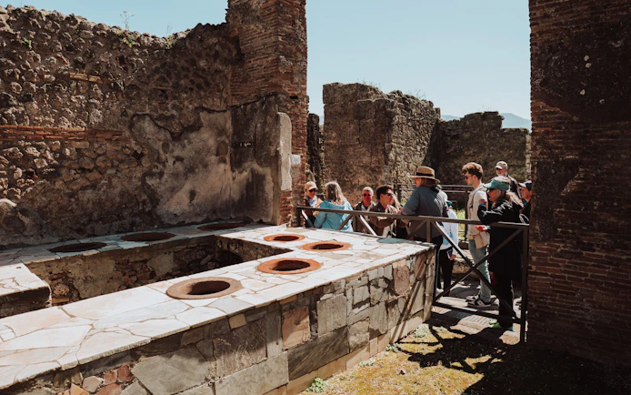Tour group exploring ancient ruins in Pompeii, Italy.