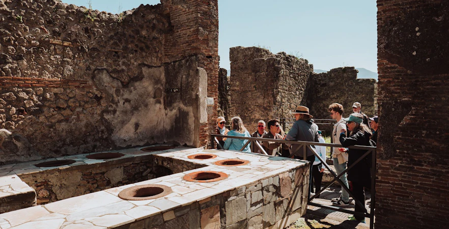 Tour group exploring ancient ruins in Pompeii, Italy.