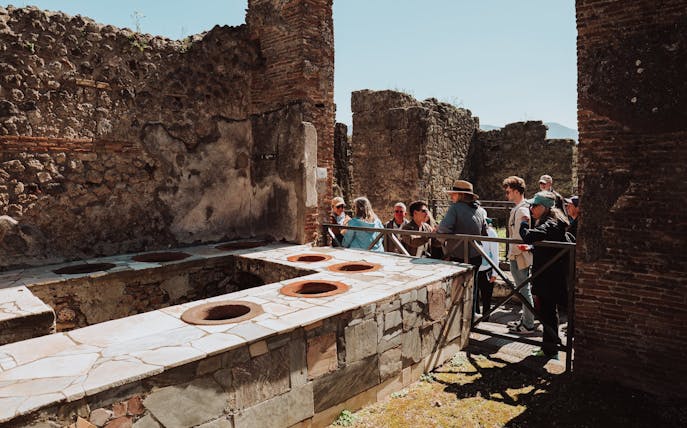 Tour group exploring ancient ruins in Pompeii, Italy.
