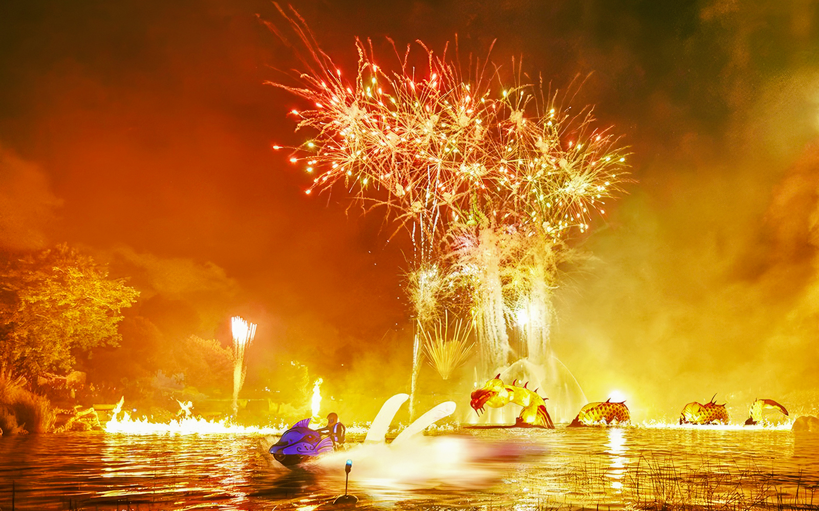 Fireworks display over water with dragon sculpture at PortAventura Park.