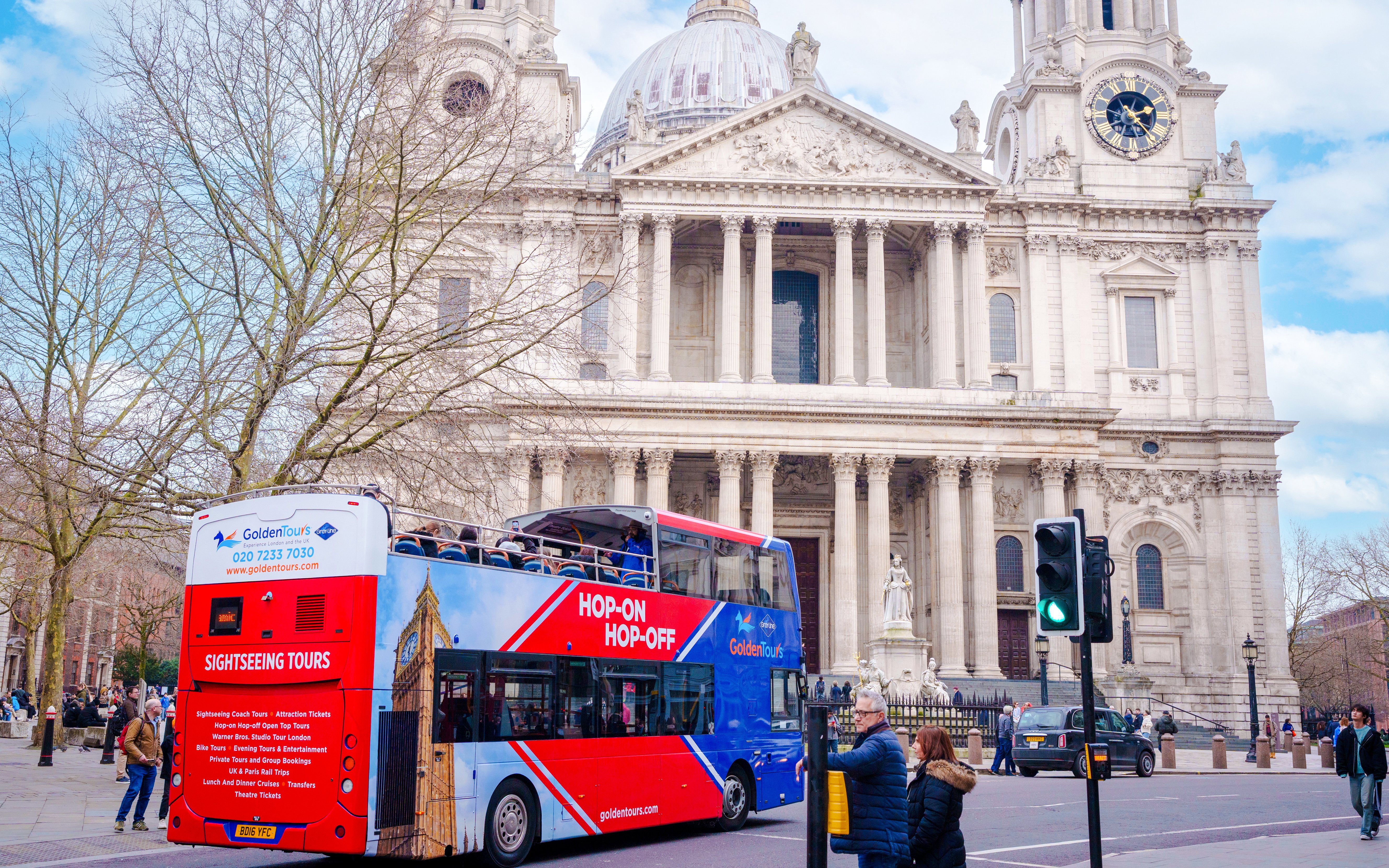 Open-top Golden Tours bus in front of St. Paul's Cathedral, London.