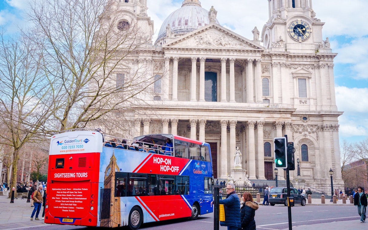 Open-top Golden Tours bus in front of St. Paul's Cathedral, London.