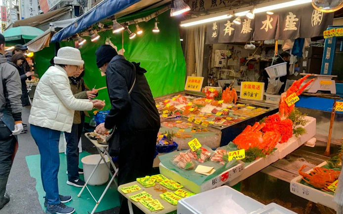 Customers purchasing seafood at Tsukiji Fish Market in Tokyo.