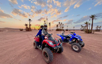 Two people on a quad bike in the palm grove at sunset, Marrakech.