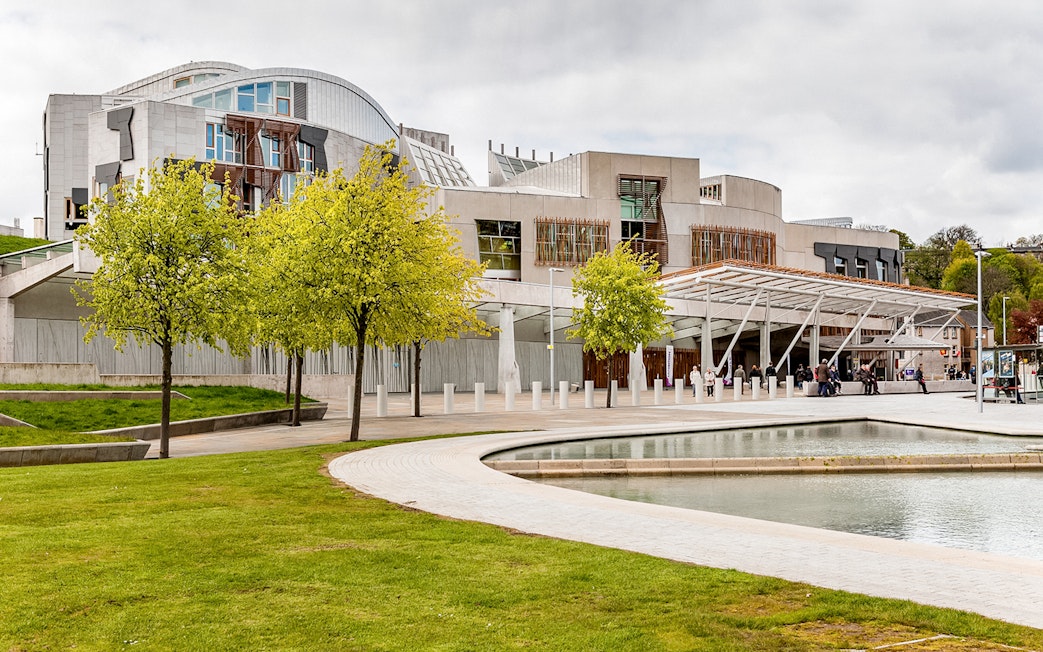 Scottish Parliament building in Edinburgh with modern architecture and surrounding greenery.