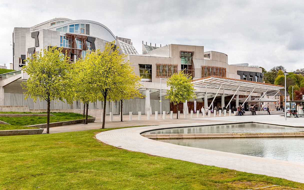 Scottish Parliament building in Edinburgh with modern architecture and surrounding greenery.