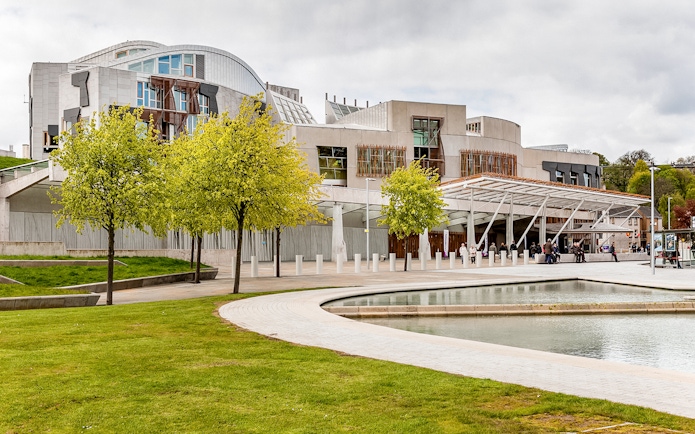 Scottish Parliament building in Edinburgh with modern architecture and surrounding greenery.