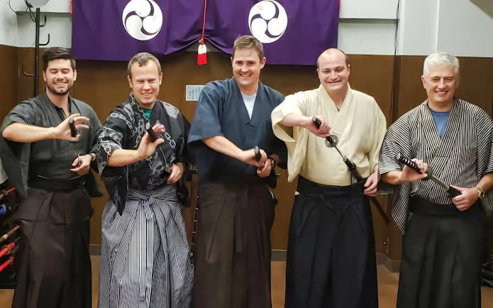 Tourists in traditional attire holding swords at a Samurai Experience.