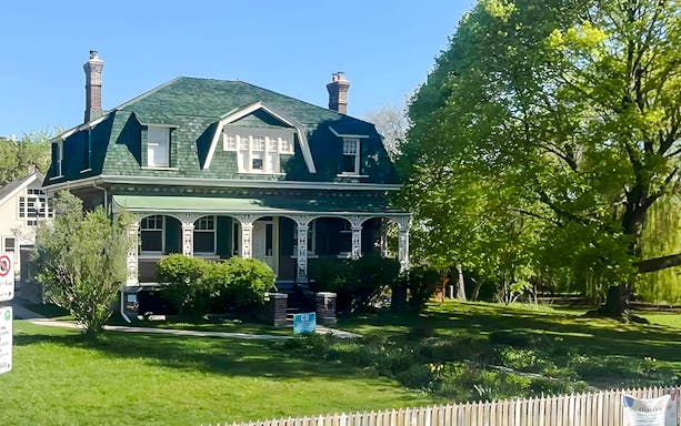 Historic house at Ashbridge Estate surrounded by lush greenery and trees.