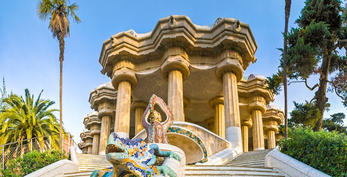 Park Guell entrance with colorful mosaic tiles and architectural details in Barcelona, Spain.