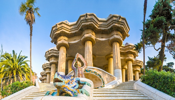 Park Guell entrance with colorful mosaic tiles and architectural details in Barcelona, Spain.