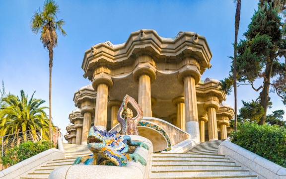 Park Guell entrance with colorful mosaic tiles and architectural details in Barcelona, Spain.