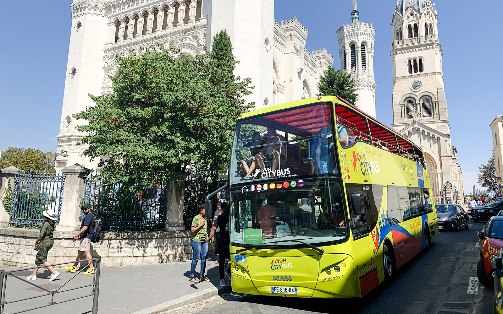 Lyon city tour bus in front of Basilica of Notre-Dame de Fourvière, France.