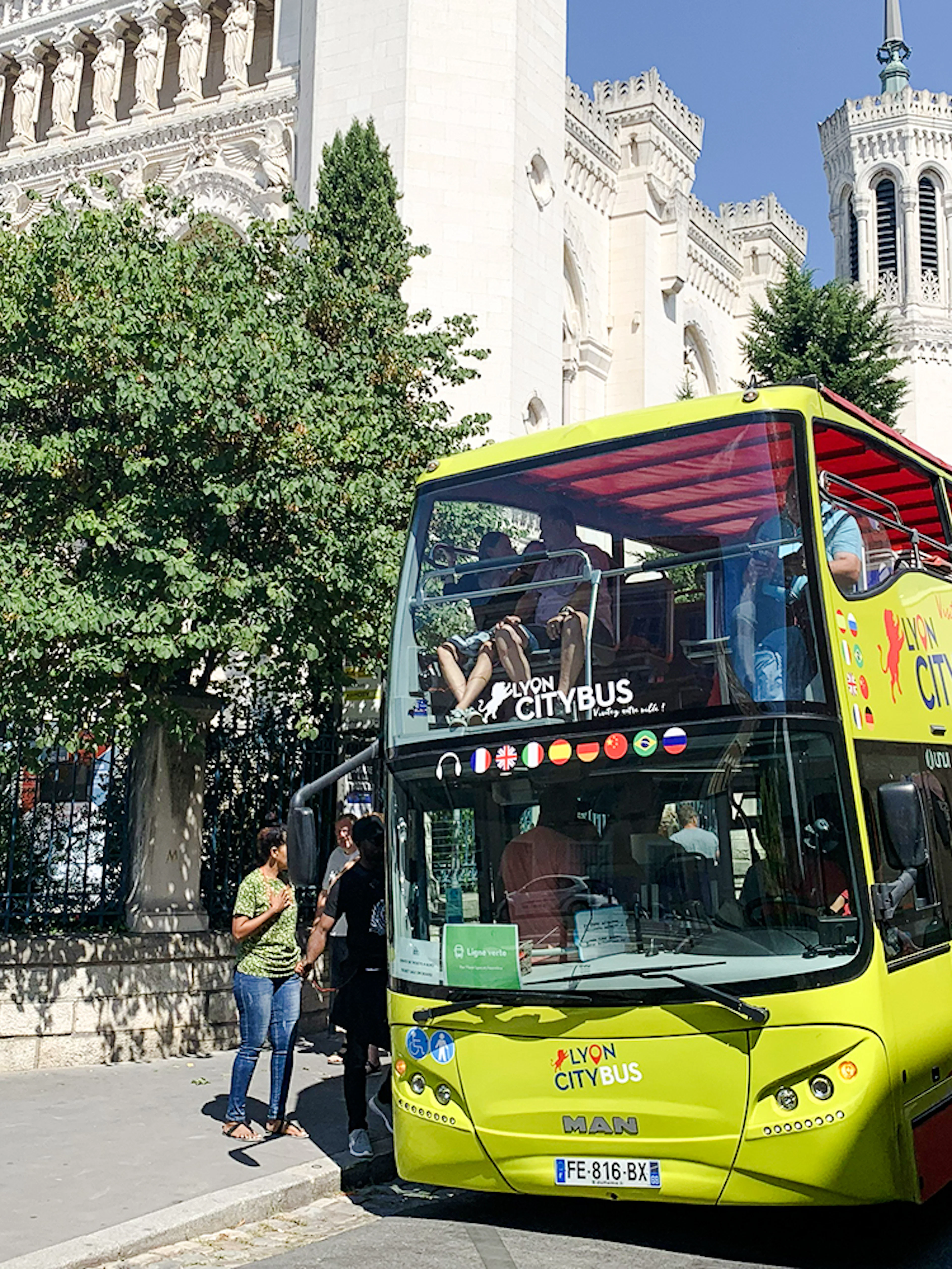 Lyon city tour bus in front of Basilica of Notre-Dame de Fourvière, France.