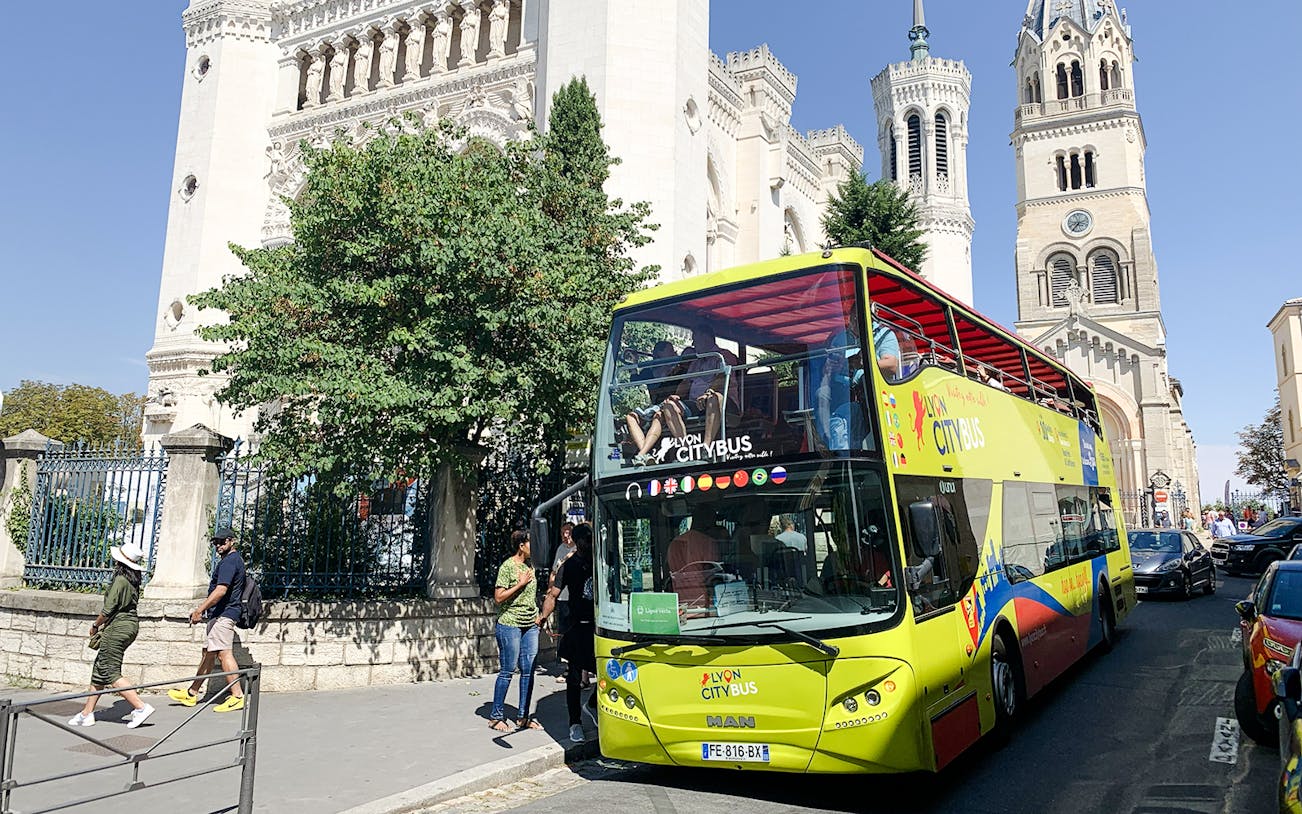 Lyon city tour bus in front of Basilica of Notre-Dame de Fourvière, France.