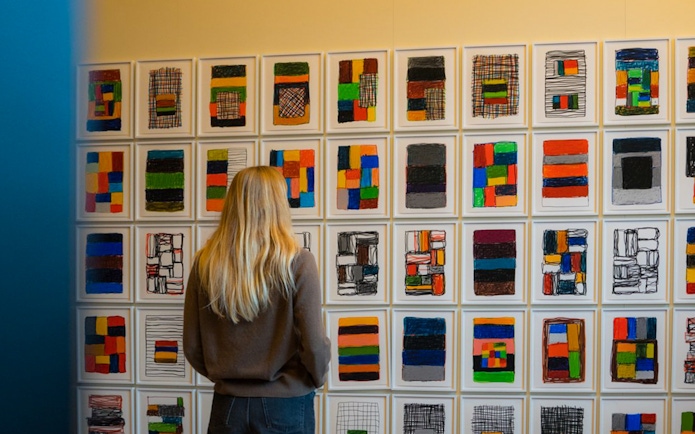 Person viewing colorful abstract art in a Copenhagen gallery.