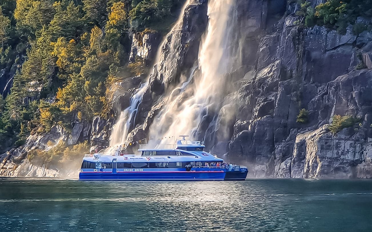 Cruise boat near a waterfall on the Rodne Fjord in Norway.