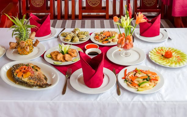 Lunch table on Ha Long Bay cruise, Vietnam, showcasing local dishes.