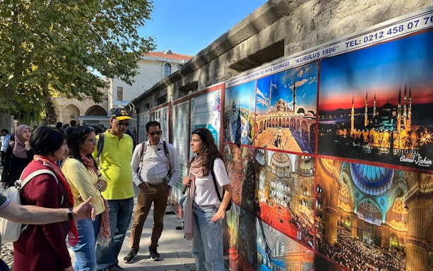 Tour group in Istanbul viewing images of top attractions with a guide.