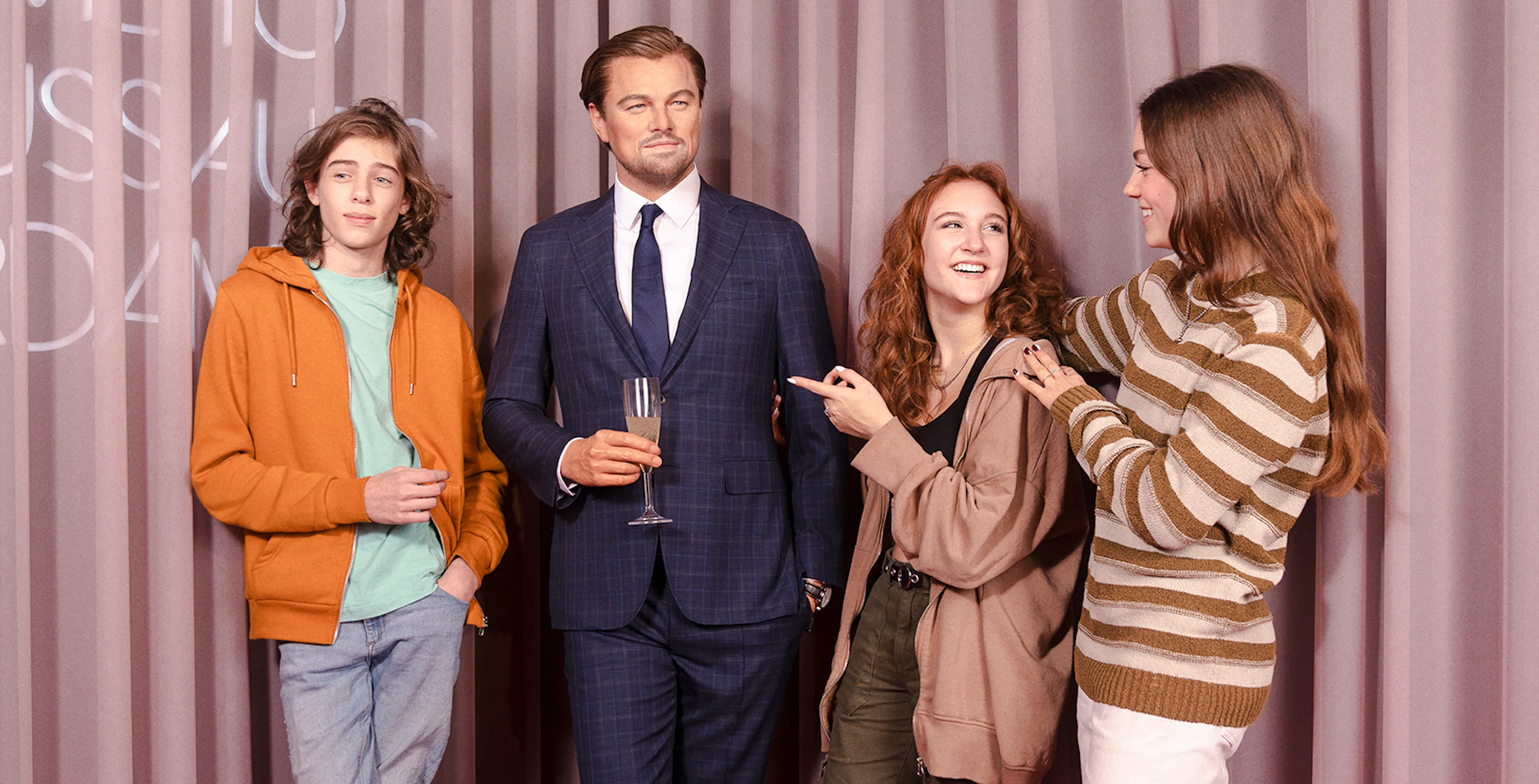 Visitors posing with a wax figure at Madame Tussauds Amsterdam.