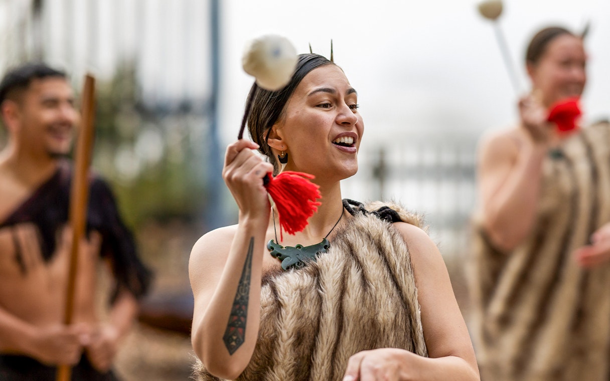 Performer in traditional Māori attire during Te Puia Haka experience, New Zealand.