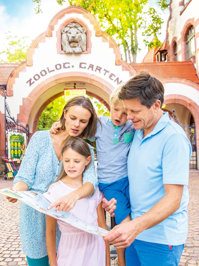 Family exploring map at Zoo Leipzig entrance.