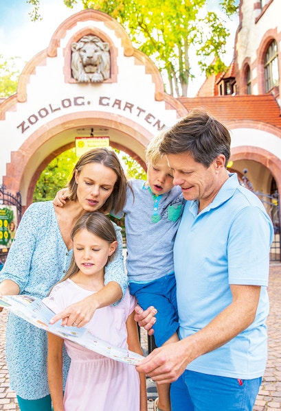 Family exploring map at Zoo Leipzig entrance.
