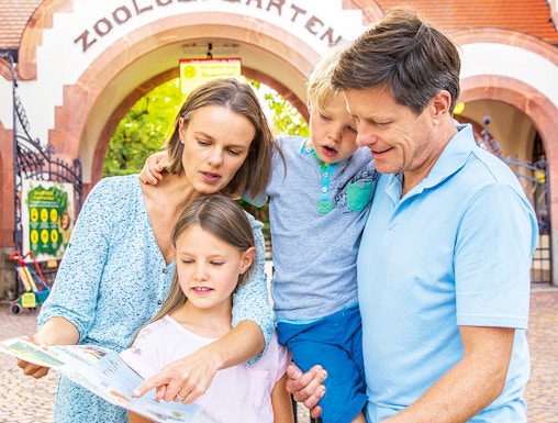 Family exploring map at Zoo Leipzig entrance.
