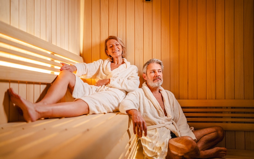 Senior couple relaxing in a wooden sauna.