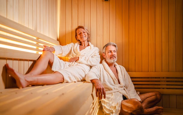 Senior couple relaxing in a wooden sauna.